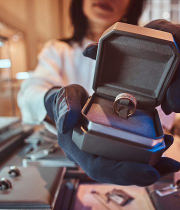 Woman assistant shows the exclusive gold ring in the jewelry store